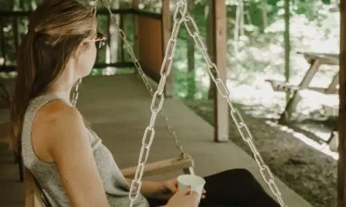 Mujer sentada en una silla colgante en la cubierta de un camarote