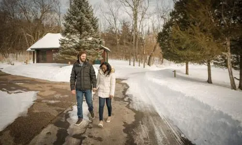Una pareja camina por un sendero rodeado de nieve