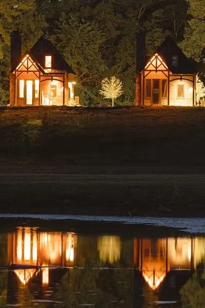 Cuatro cabinas iluminadas por la noche, reflejadas en el agua