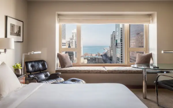Habitación de hotel con una gran ventana que da a la ciudad.