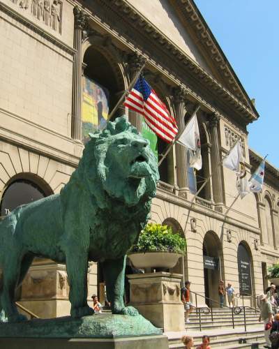 Una estatua de león frente a un gran museo