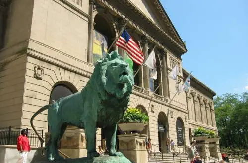 Una estatua de león frente a un gran museo