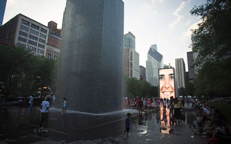 Gran fuente de agua en forma de corona con gente mirándola
