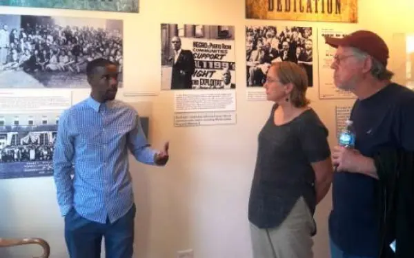 Un guía habla a los visitantes sobre una exposición ante la que se encuentran.