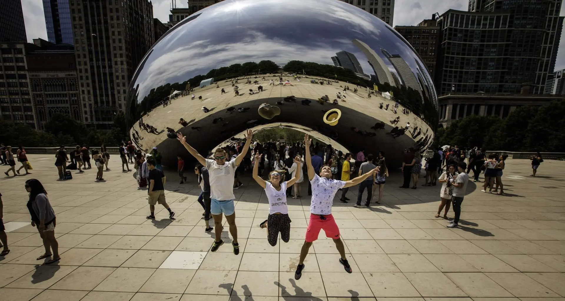 Tres personas saltan por los aires frente al monumento The Bean en Chicago