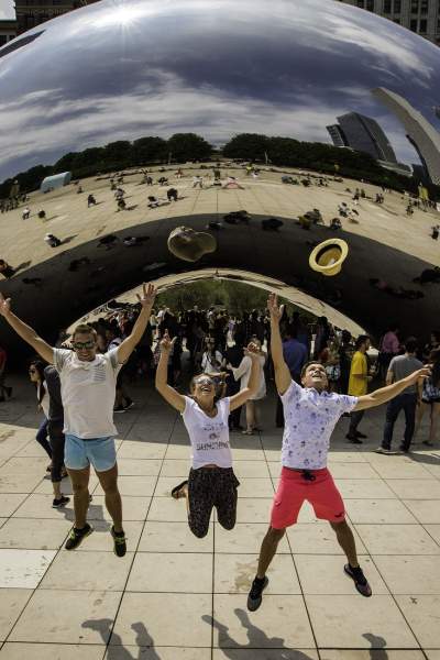 Tres personas saltan por los aires frente al monumento The Bean en Chicago