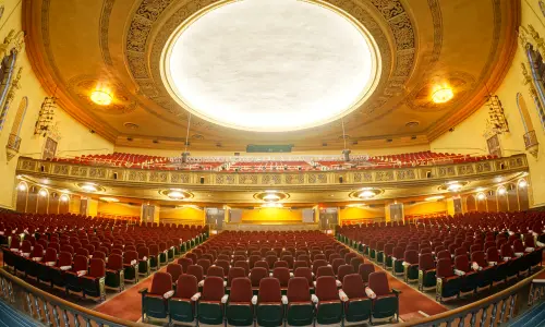 Un ornamentado auditorio teatral de dos niveles, visto desde el escenario