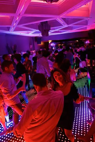 Los clientes bailan en una pista iluminada