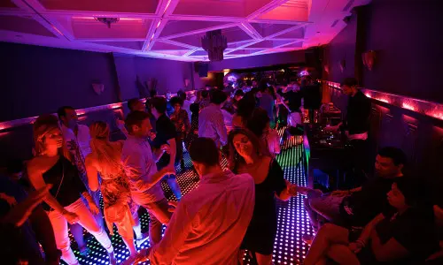 Los clientes bailan en una pista iluminada