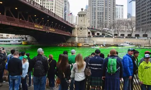 Una multitud observa cómo se tiñe el río