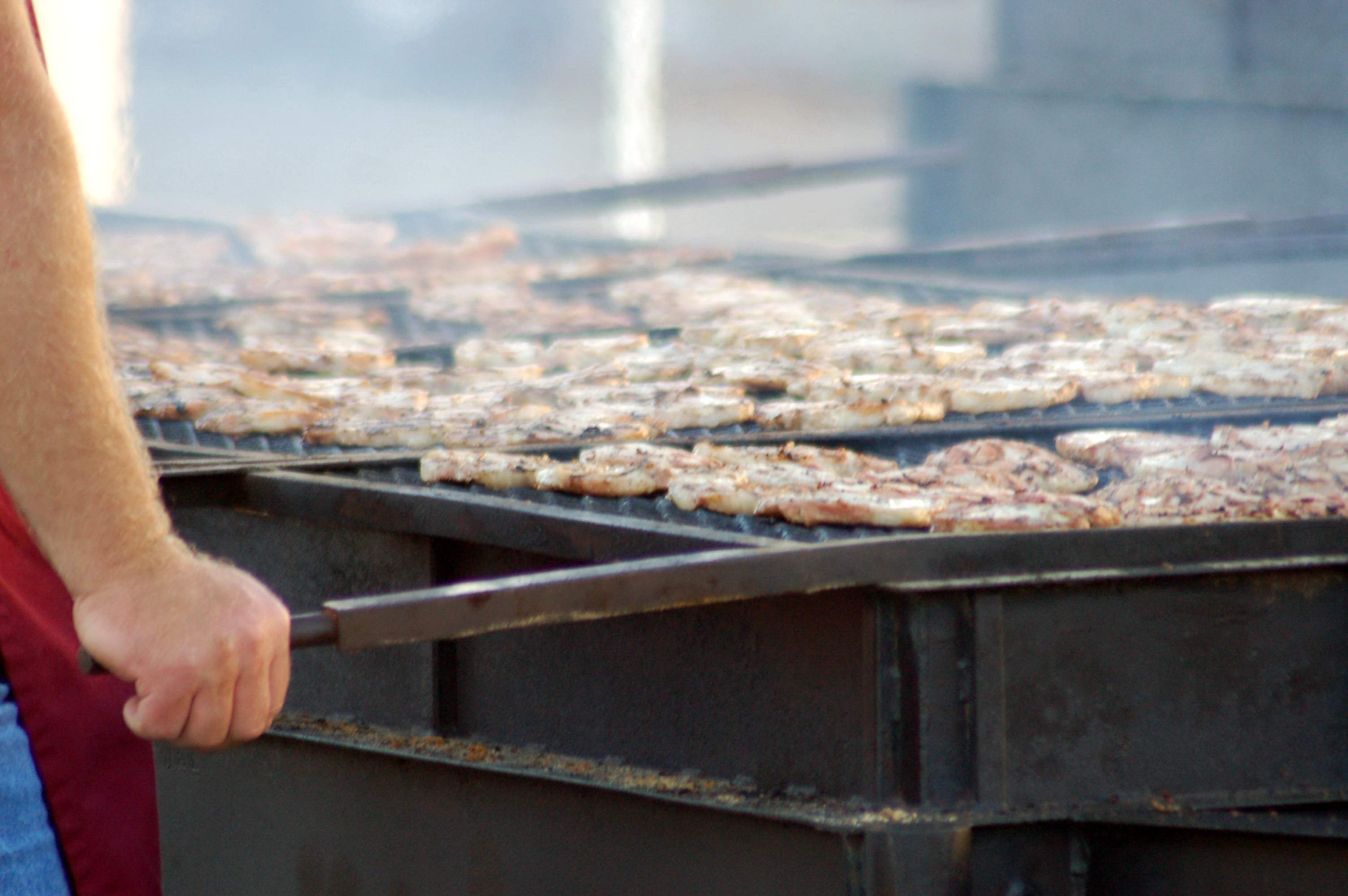 Un cocinero de barbacoa asando chuletas de cerdo en el Kewanee Hog Days