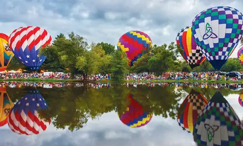 Globos aerostáticos rodean un lago (Foto Don Burkett)