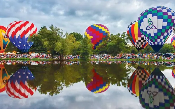 Globos aerostáticos rodean un lago (Foto Don Burkett)