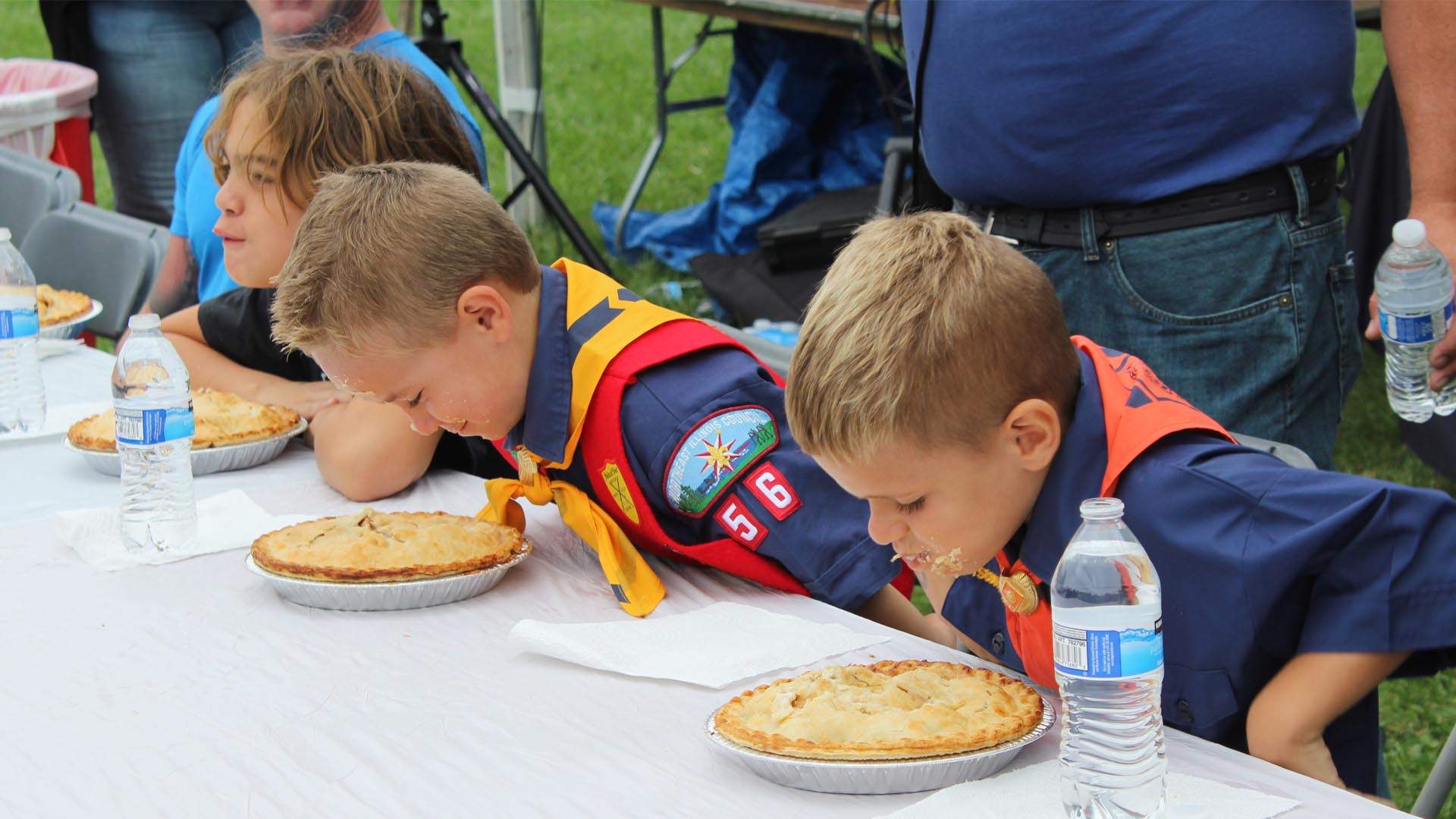 Chicos participando en una competición de comer tartas en la Fiesta de la Fresa de Long Grove.