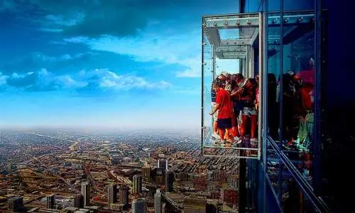 Gente de pie en Skydeck mirando los edificios de abajo
