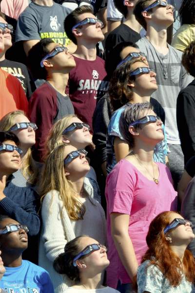 La gente mira al cielo durante el eclipse solar