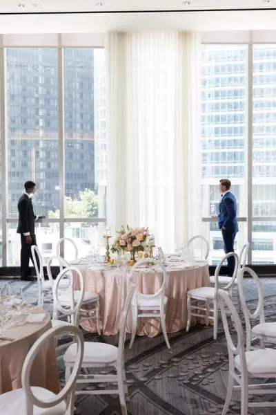 Dos hombres en un comedor preparado para una boda