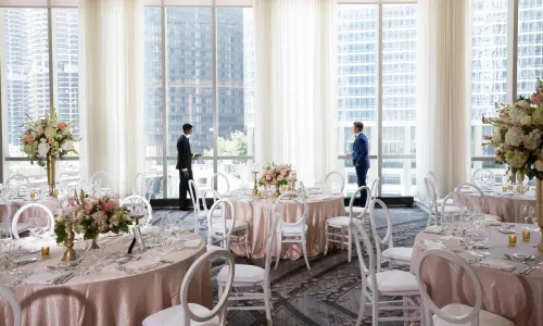 Dos hombres en un comedor preparado para una boda