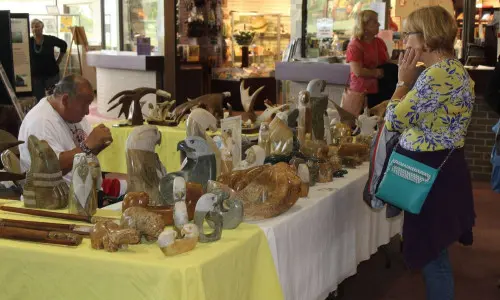 Una mujer mira obras de arte en un mercadillo navideño
