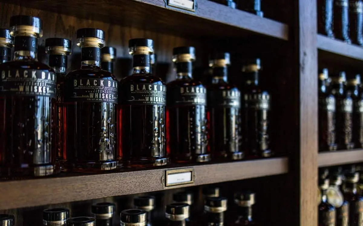 Botellas de whisky apiladas en estanterías