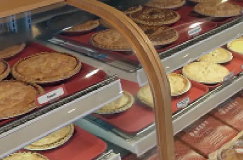 Una vitrina de panadería llena de tartas. 