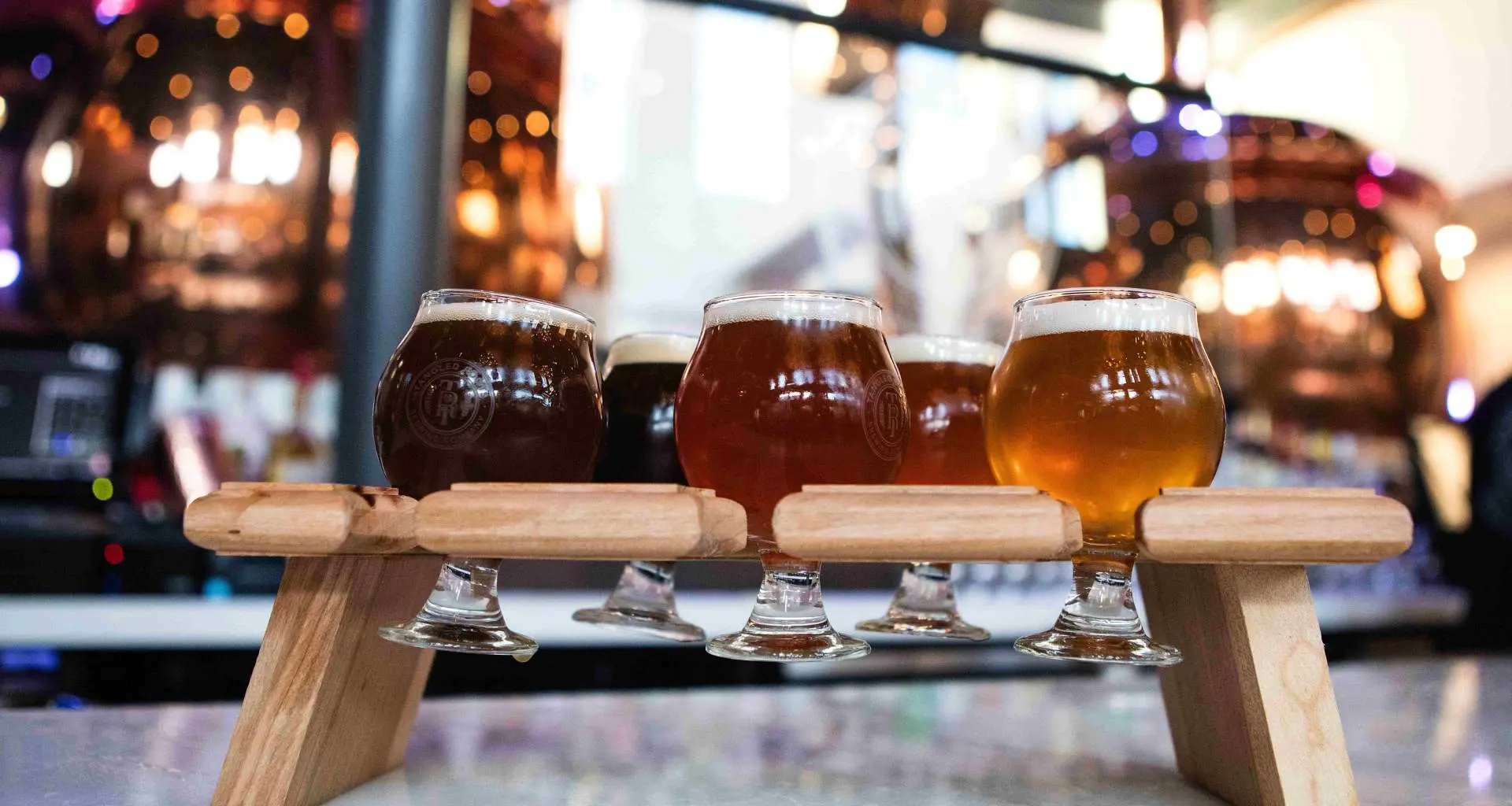 cinco cervezas artesanales en un stand