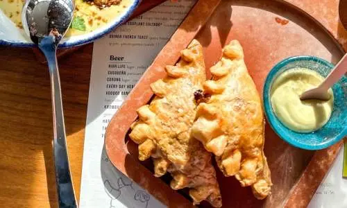 Empanadas y otros alimentos en una mesa de Cabra en Chicago
