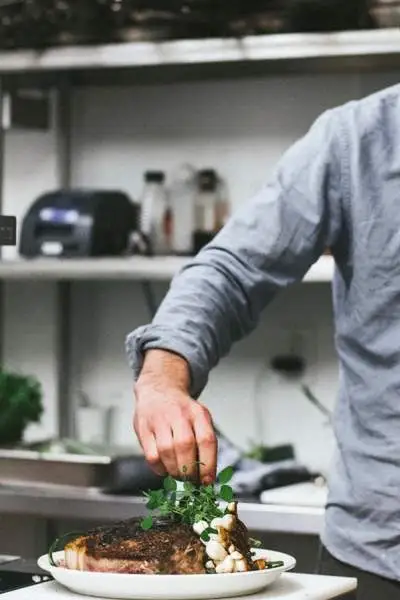 Un chef emplata una comida de restaurante 