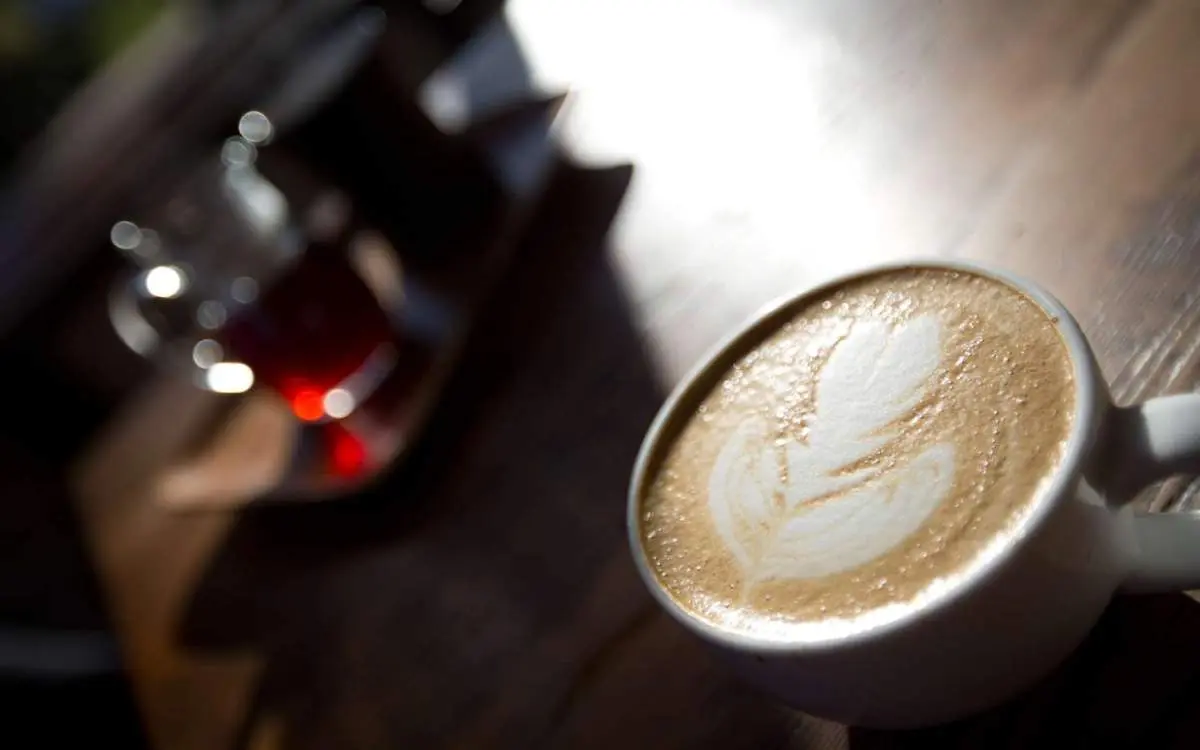 Una taza de café con leche en forma de hoja perfecta hecha con espuma de leche