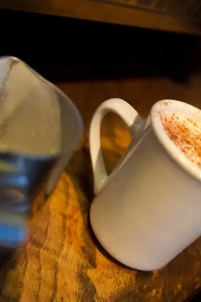 Una taza de café llena hasta arriba con un café con leche y especias de calabaza