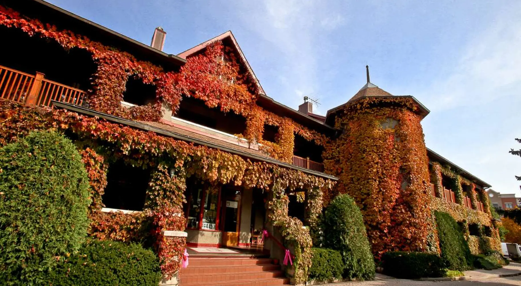 El exterior del edificio cubierto de hojas naranjas durante el otoño