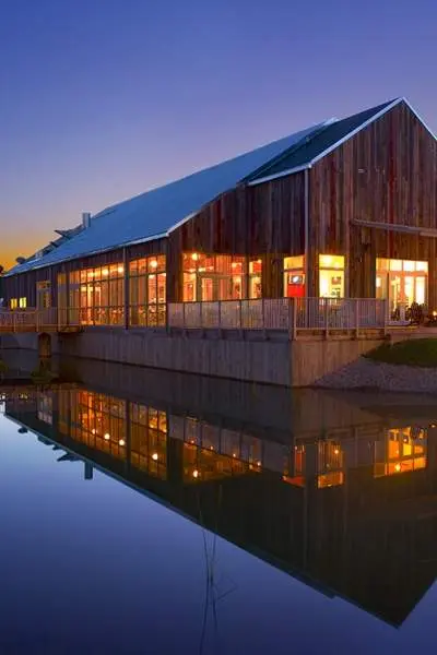 Una foto del asador Firefly durante la puesta de sol con el lago reflejando el edificio.