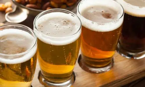 Cuatro vasos de cerveza en una paleta de madera