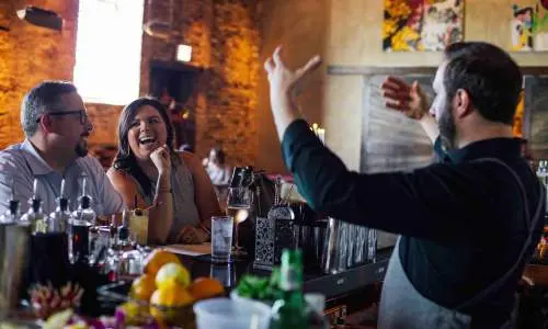 Camarero entreteniendo a los clientes. 