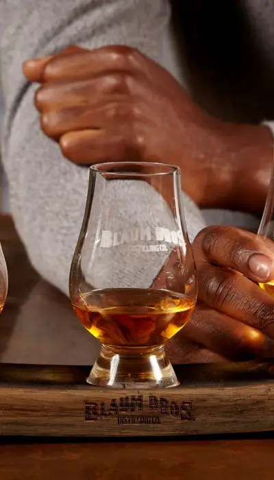 Tres vasos de whisky con la marca Blaum Bros.