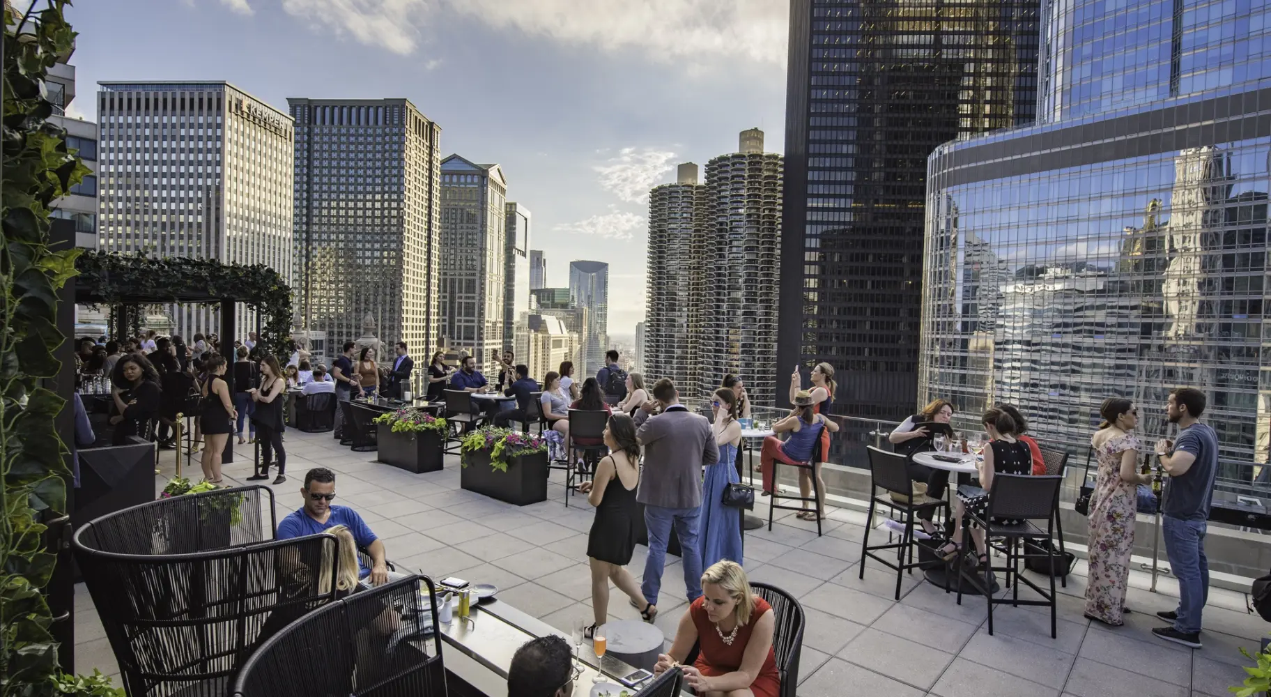 La gente se reunió en un bar en la azotea entre las cimas de los rascacielos