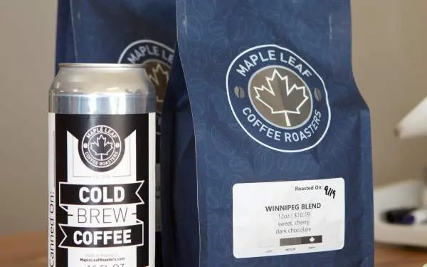 Lata de café en frío junto a bolsas de café