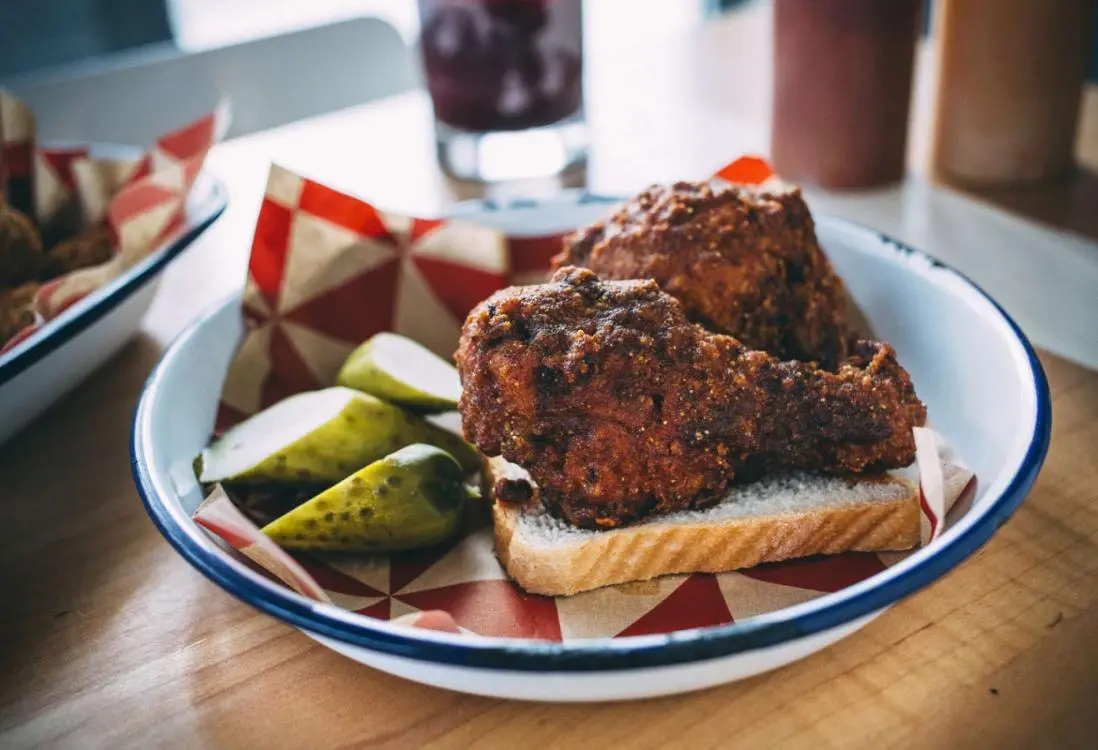 Dos muslos de pollo y pepinillos en un trozo de pan
