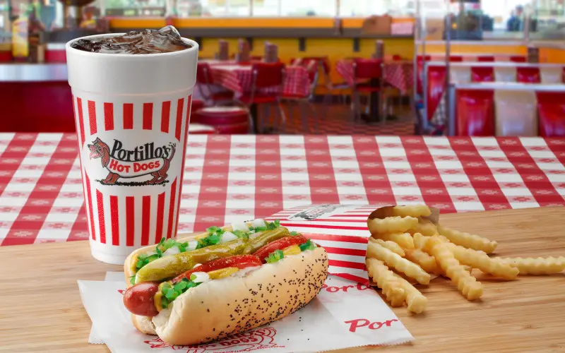 Coca-Cola, un perrito caliente y patatas fritas en una mesa