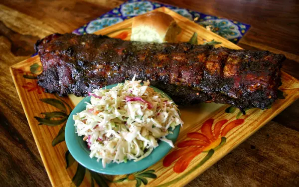 Costillas a la barbacoa y un panecillo y ensalada de repollo
