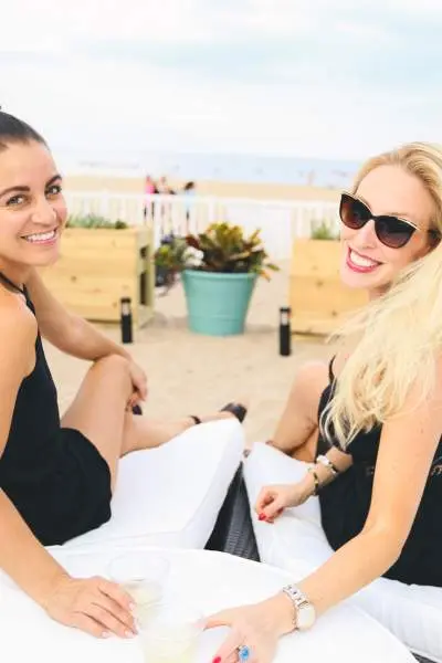 Dos mujeres tomando una copa en una tumbona de playa