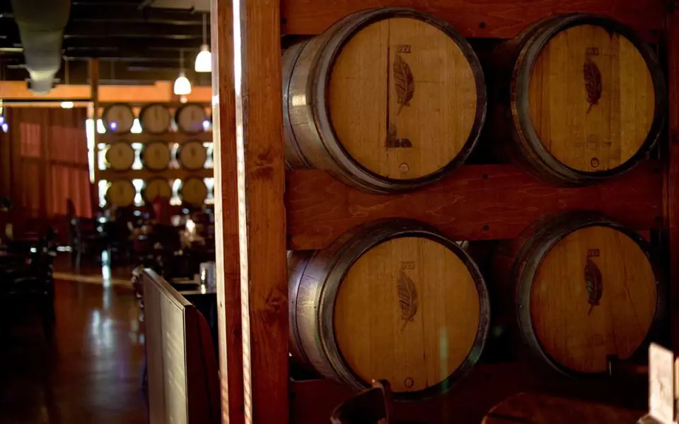 Una hilera de barriles de vino en un cuarto oscuro