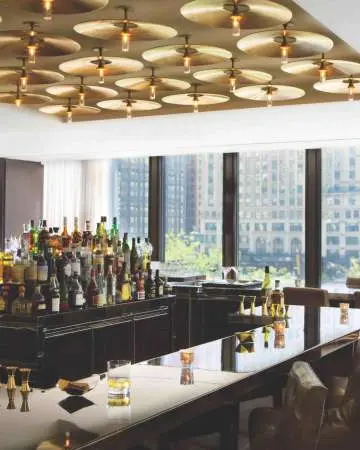 Interior de un bar con muchas ventanas que dan a la ciudad.