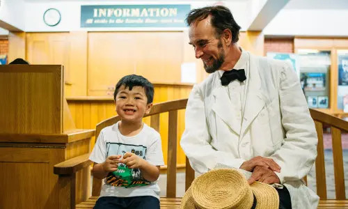 Un niño y un hombre sentados en una silla en una habitación
