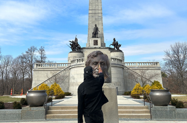 Sherman "Dilla" Thomas frota el busto de bronce de Abraham Lincoln en su tumba de Springfield.