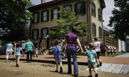 Una madre y sus hijos caminan hacia la casa de Lincoln en el Lincoln Home Historic Site de Springfield.