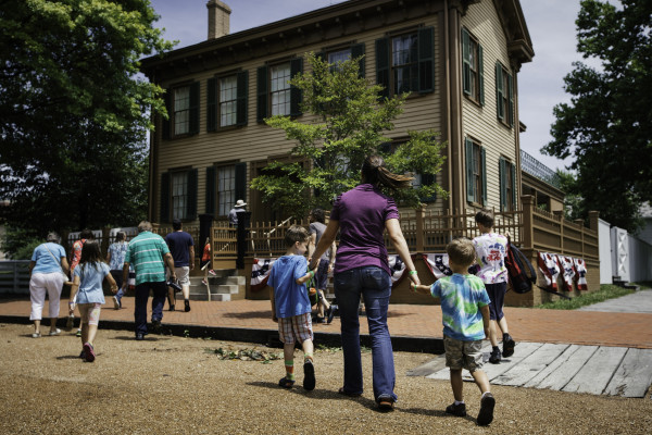 Una madre y sus hijos caminan hacia la casa de Lincoln en el Lincoln Home Historic Site de Springfield.