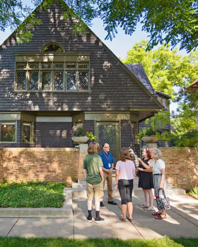 Un guía habla con un grupo de turistas en la acera frente a la casa y el estudio de Frank Lloyd Wright en Oak Park.