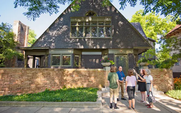 Un guía habla con un grupo de turistas en la acera frente a la casa y el estudio de Frank Lloyd Wright en Oak Park.