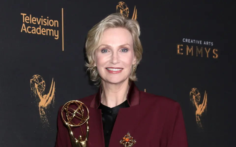 Jane Lynch sosteniendo su premio Emmy